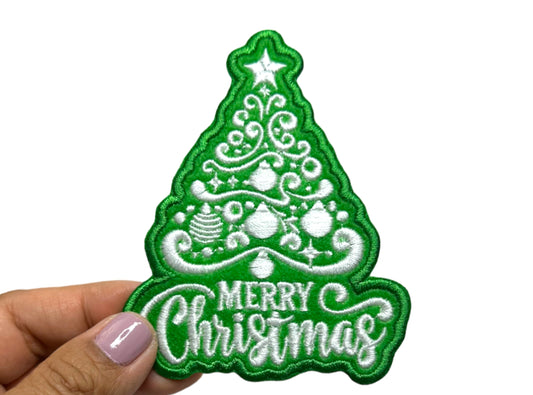 Close-up of the Christmas tree patch held between fingers showing stitch detail