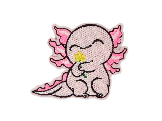 Embroidered patch of a cute pink axolotl sitting and holding a yellow flower. The design features a kawaii style with dark pink gills, a sweet smile, and black outlined details.