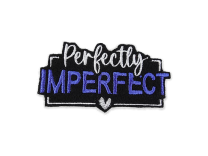 Embroidered "Perfectly Imperfect" patch featuring vibrant blue lettering on a solid black background, finished with a crisp white border and small heart detail.