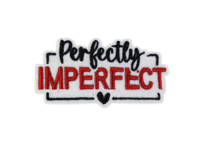 Embroidered "Perfectly Imperfect" patch featuring a white background with bold red block lettering for "IMPERFECT" and black script for "Perfectly," finished with a black heart detail.
