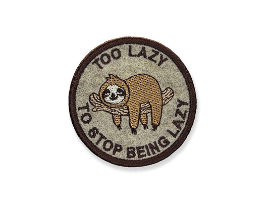 Funny sloth embroidered patch with "Too Lazy to Stop Being Lazy" text in a circular design, featuring a cute hanging sloth on a tan fabric background with a brown border