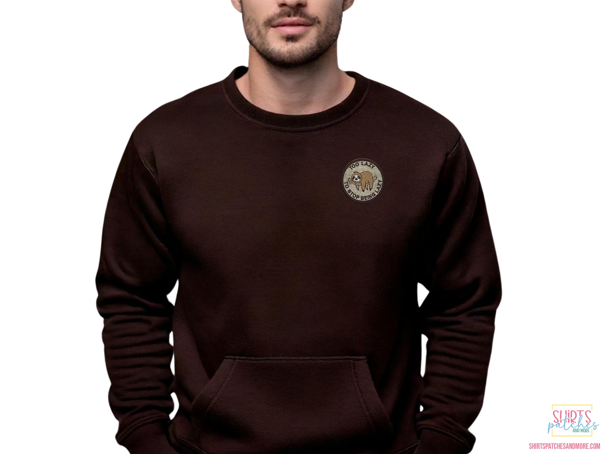 Lifestyle shot of a "Too Lazy to Stop Being Lazy" sloth embroidered patch applied to the chest of a dark brown crewneck sweatshirt to show scale and apparel application.