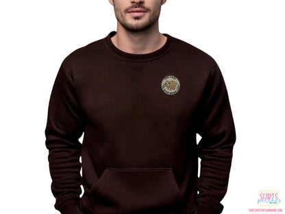Lifestyle shot of a "Too Lazy to Stop Being Lazy" sloth embroidered patch applied to the chest of a dark brown crewneck sweatshirt to show scale and apparel application.