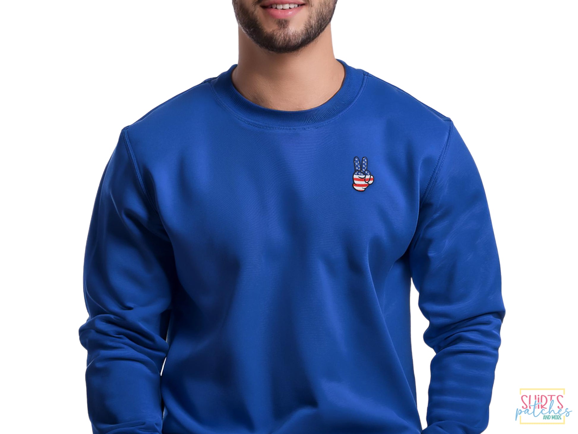 Model wearing a blue sweatshirt featuring a small embroidered peace sign hand patch with a red, white, and blue American flag stars and stripes design.