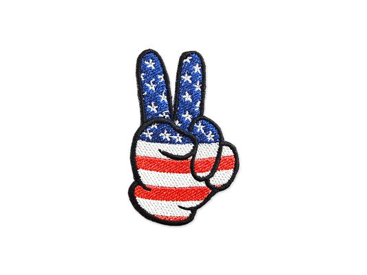 Hand-embroidered peace sign patch featuring a red, white, and blue American flag stars and stripes design on a white background.