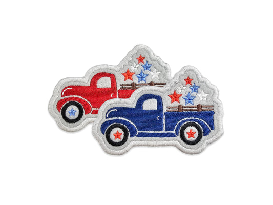 Two vintage pickup trucks, one red and one blue, both featuring star-filled truck beds and patriotic stars-and-stripes embroidery on a white background.