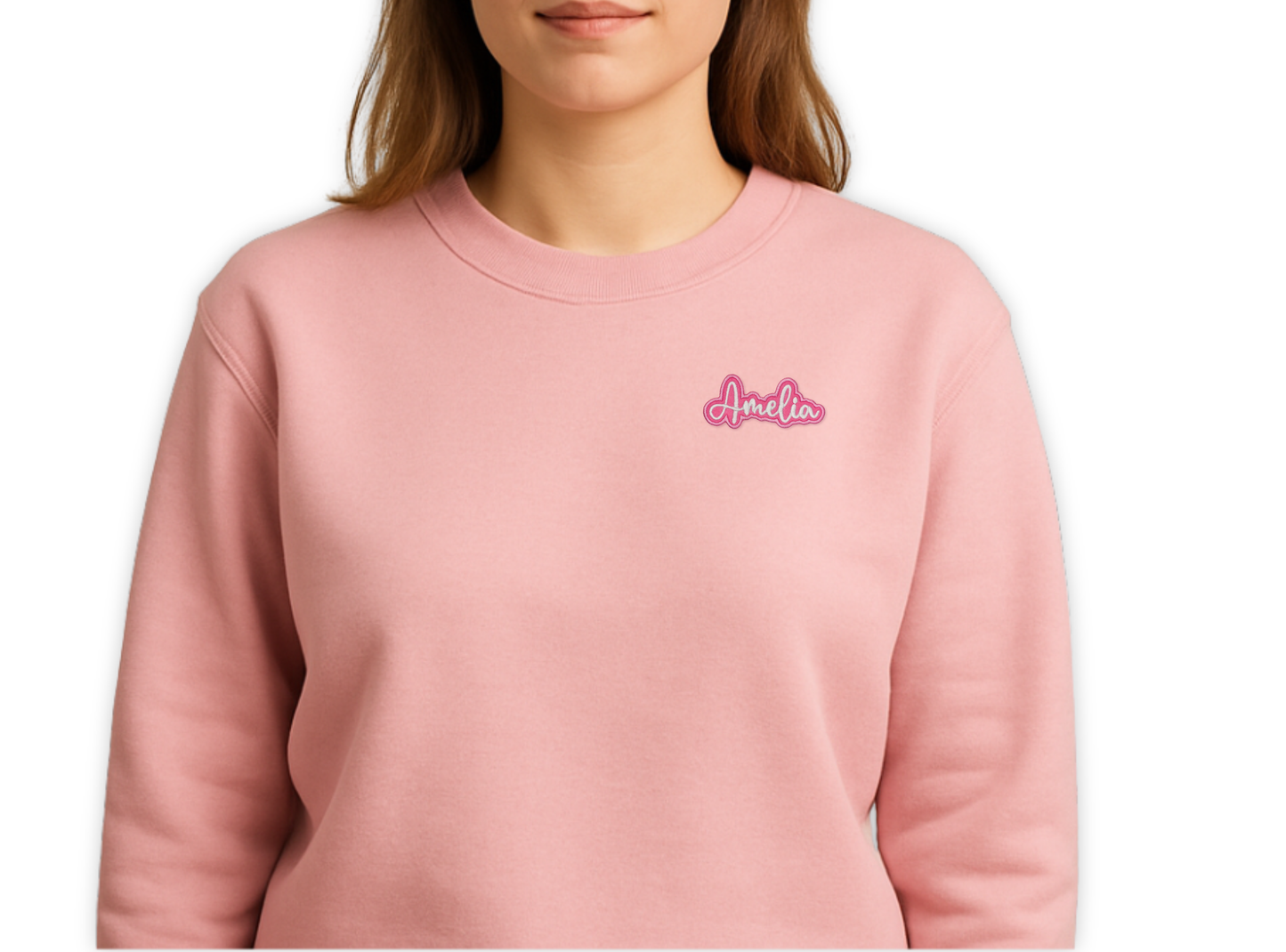 Person wearing a pink sweatshirt with 'Amelia' embroidered on it against a white background