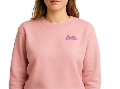Person wearing a pink sweatshirt with 'Amelia' embroidered on it against a white background
