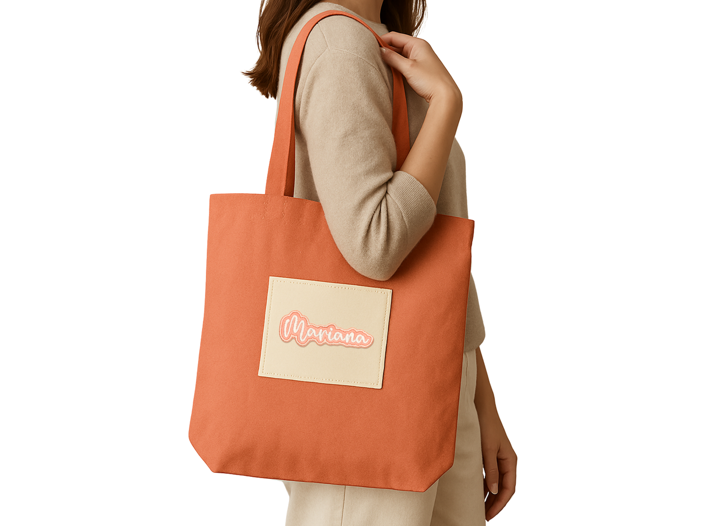 Mariana embroidered name patch applied to an orange tote bag being carried over the shoulder