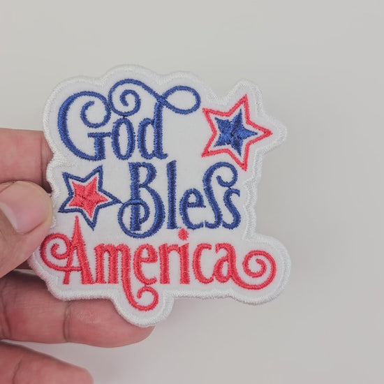 Product showcase video for a patriotic "God Bless America" patch featuring high-quality embroidery and vibrant red and navy blue script.