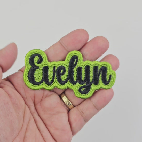 Short video demonstrating the finished quality, stitching, and texture of the personalized Evelyn name patch in black and lime green embroidery.