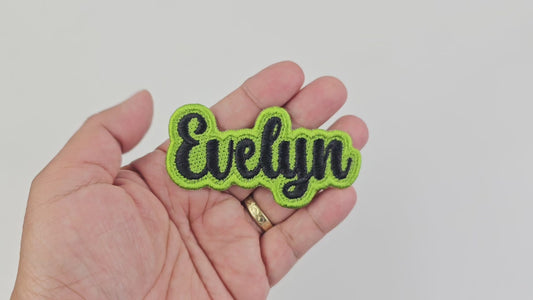 Short video demonstrating the finished quality, stitching, and texture of the personalized Evelyn name patch in black and lime green embroidery.