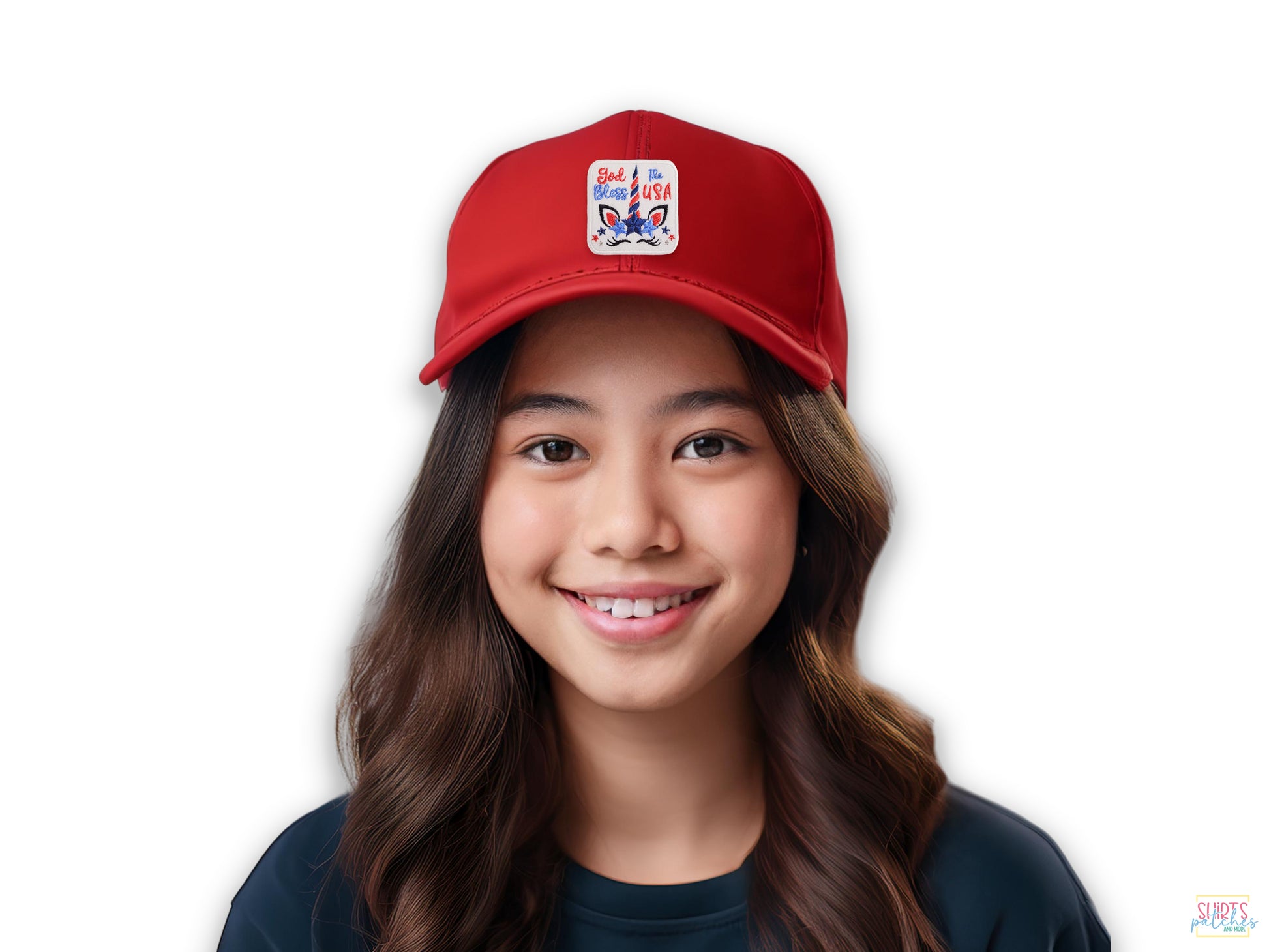 A smiling young woman wearing a red baseball cap featuring a 'God Bless The USA' patriotic unicorn patch on the front.